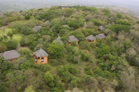 Aerial view of Hilltop Camp's thatched chalets on the forested ridge at 450 metres, Hluhluwe-iMfolozi Game Reserve, KwaZulu-Natal, South Africa